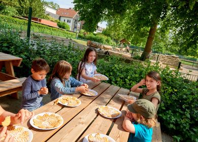 Kinder essen Waffeln im Witthausbusch in Mülheim an der Ruhr. 
